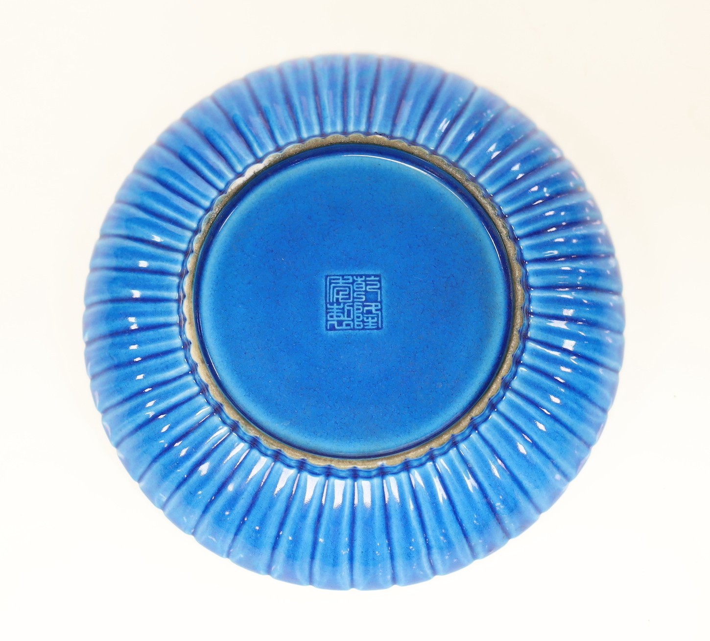 A Chinese blue monochrome earthenware dish, 15.5 cms diameter